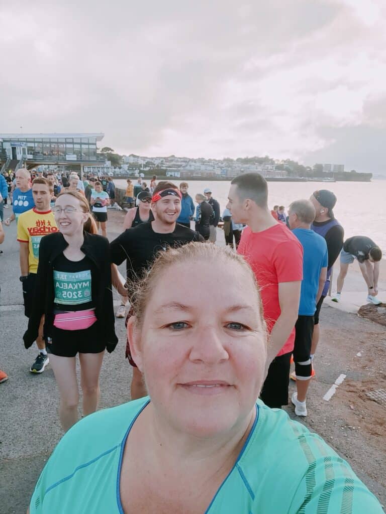 Susan representing Carn Runners at the Torbay Half Marathon finish line