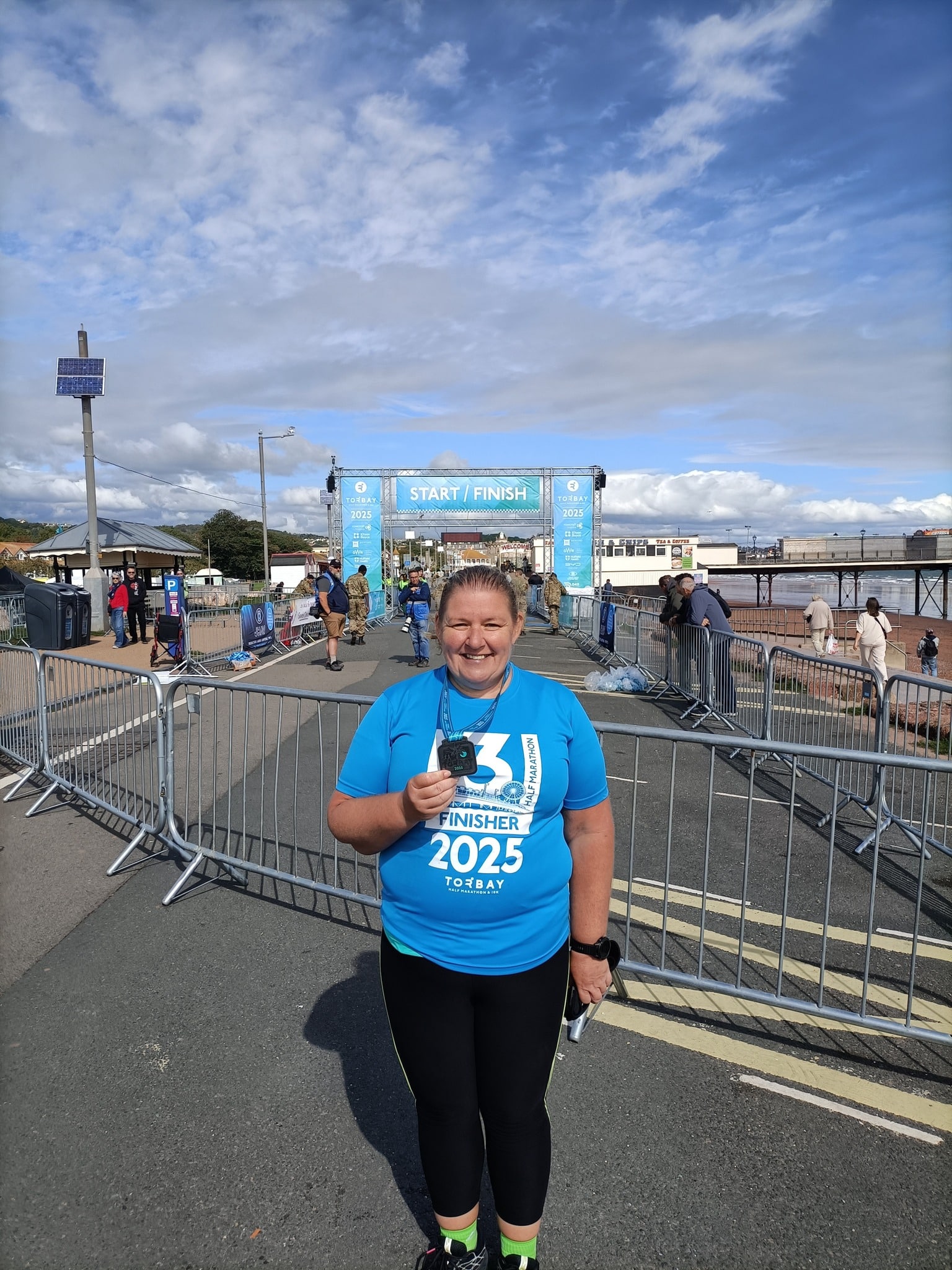 Susan representing Carn Runners at the Torbay Half Marathon finish line