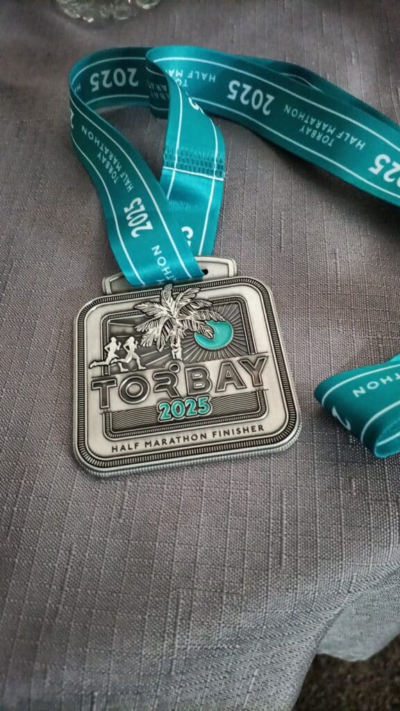 Susan representing Carn Runners at the Torbay Half Marathon finish line