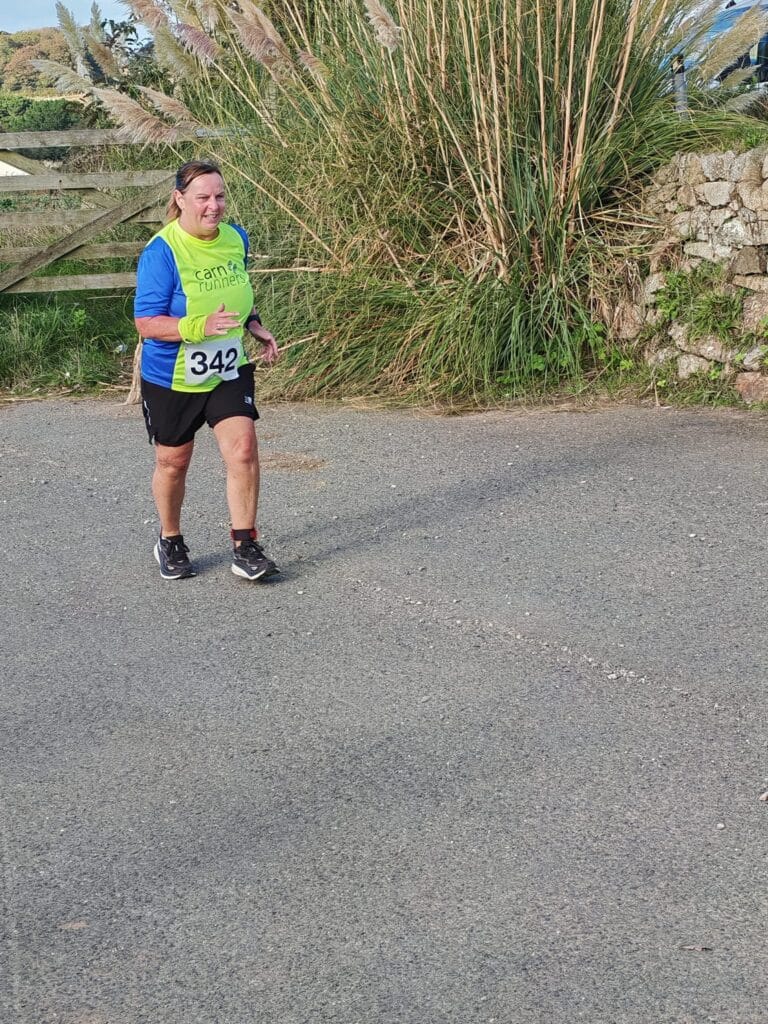 Carn Runners team at the Marazion 10K with Cornish coastline in the background