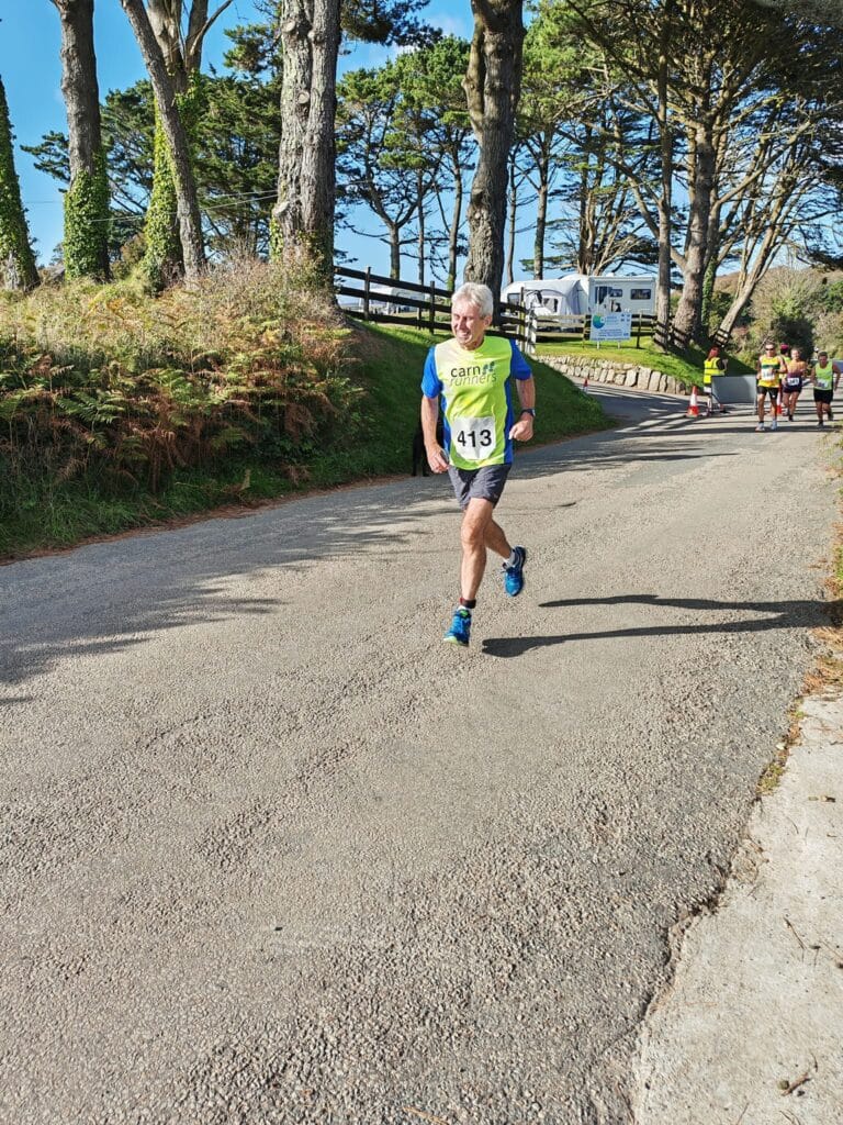 Carn Runners team at the Marazion 10K with Cornish coastline in the background