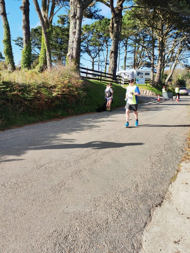Carn Runners team at the Marazion 10K with Cornish coastline in the background