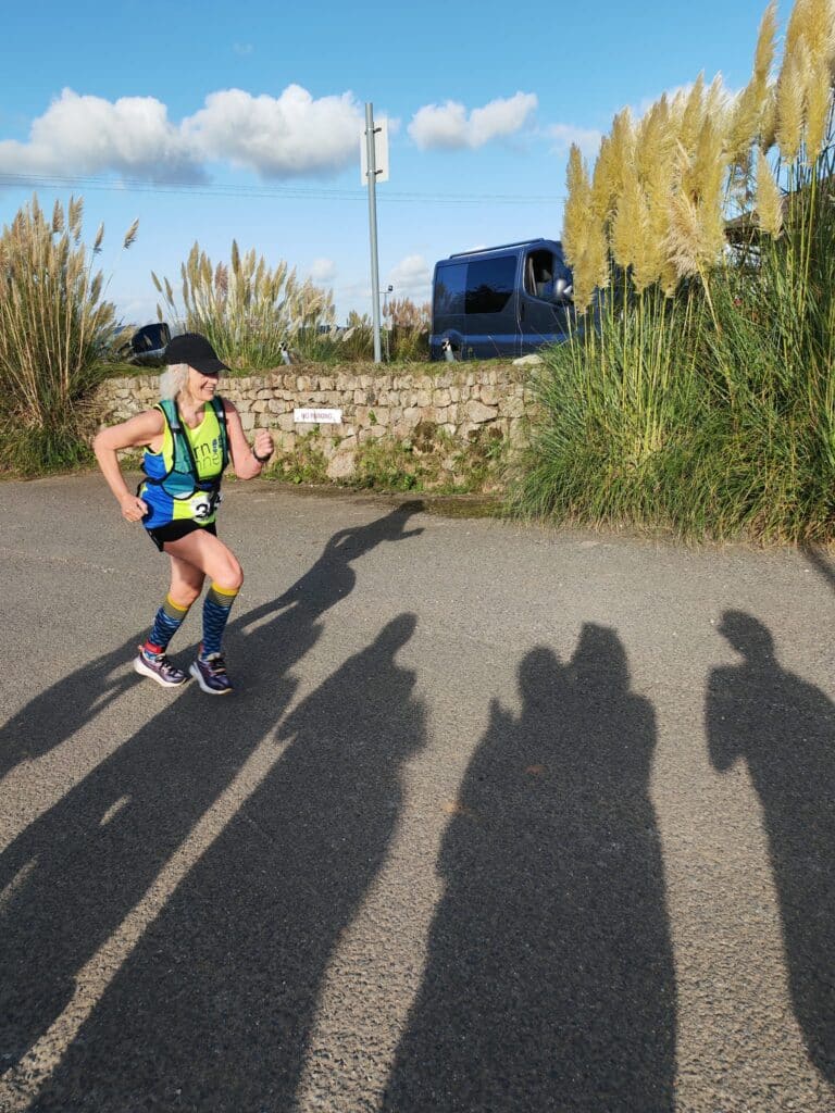 Carn Runners team at the Marazion 10K with Cornish coastline in the background