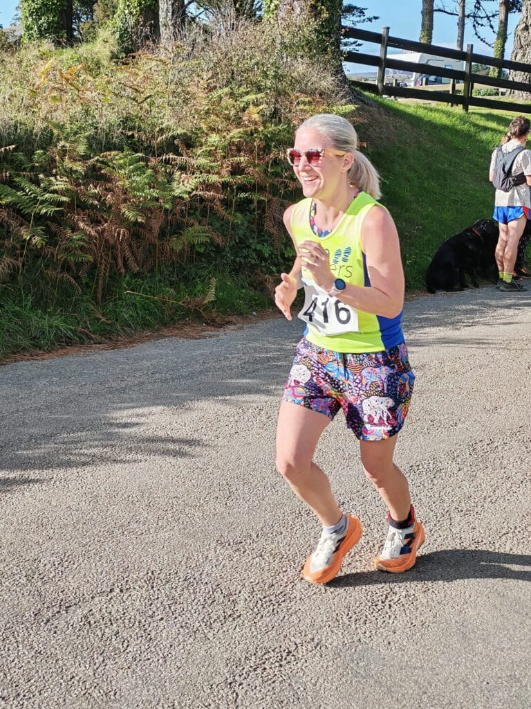 Carn Runners team at the Marazion 10K with Cornish coastline in the background