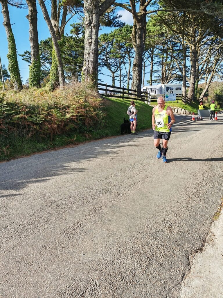 Carn Runners team at the Marazion 10K with Cornish coastline in the background