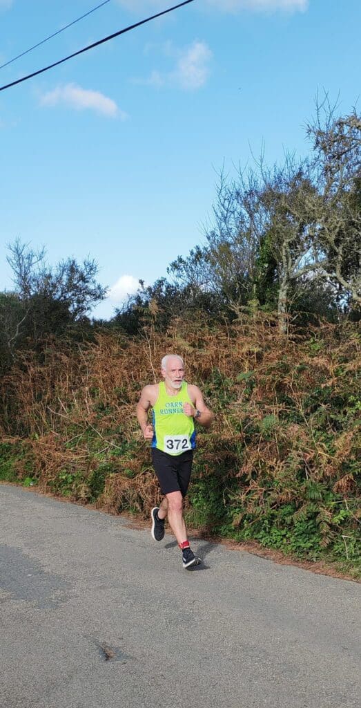 Carn Runners team at the Marazion 10K with Cornish coastline in the background