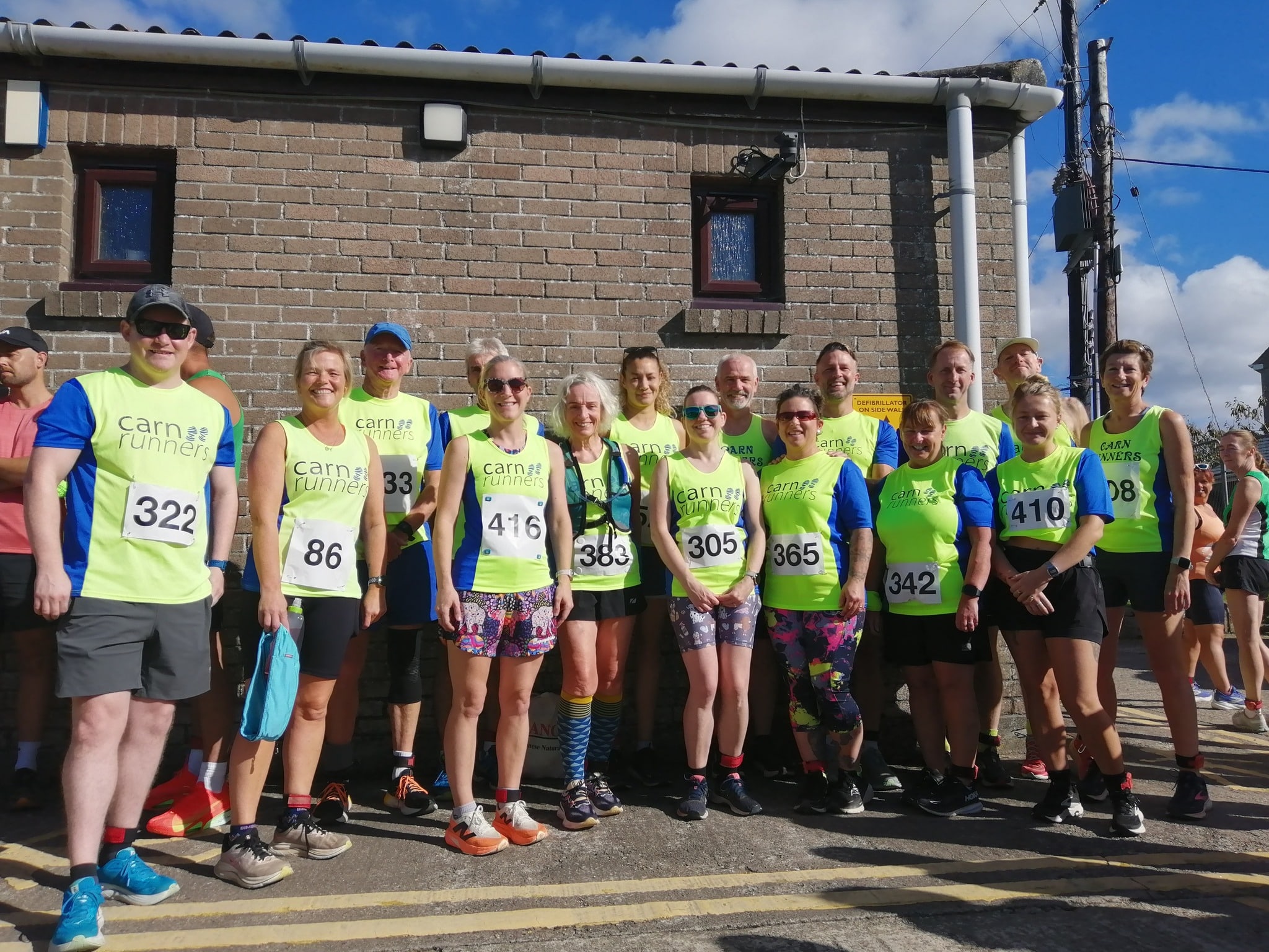 Carn Runners team at the Marazion 10K with Cornish coastline in the background