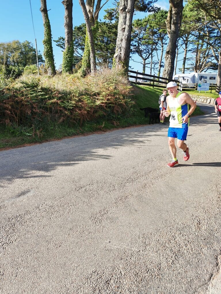 Carn Runners team at the Marazion 10K with Cornish coastline in the background
