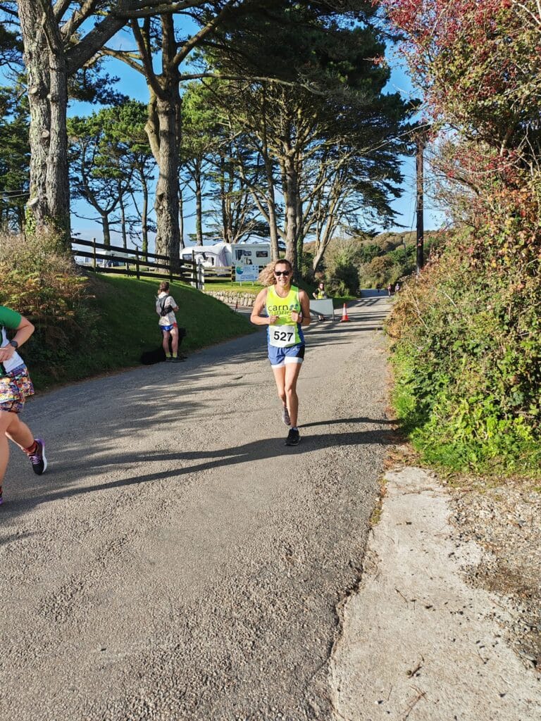 Carn Runners team at the Marazion 10K with Cornish coastline in the background