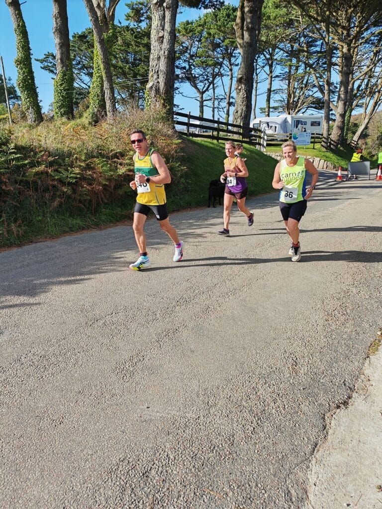 Carn Runners team at the Marazion 10K with Cornish coastline in the background