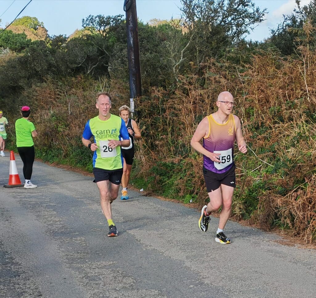 Carn Runners team at the Marazion 10K with Cornish coastline in the background