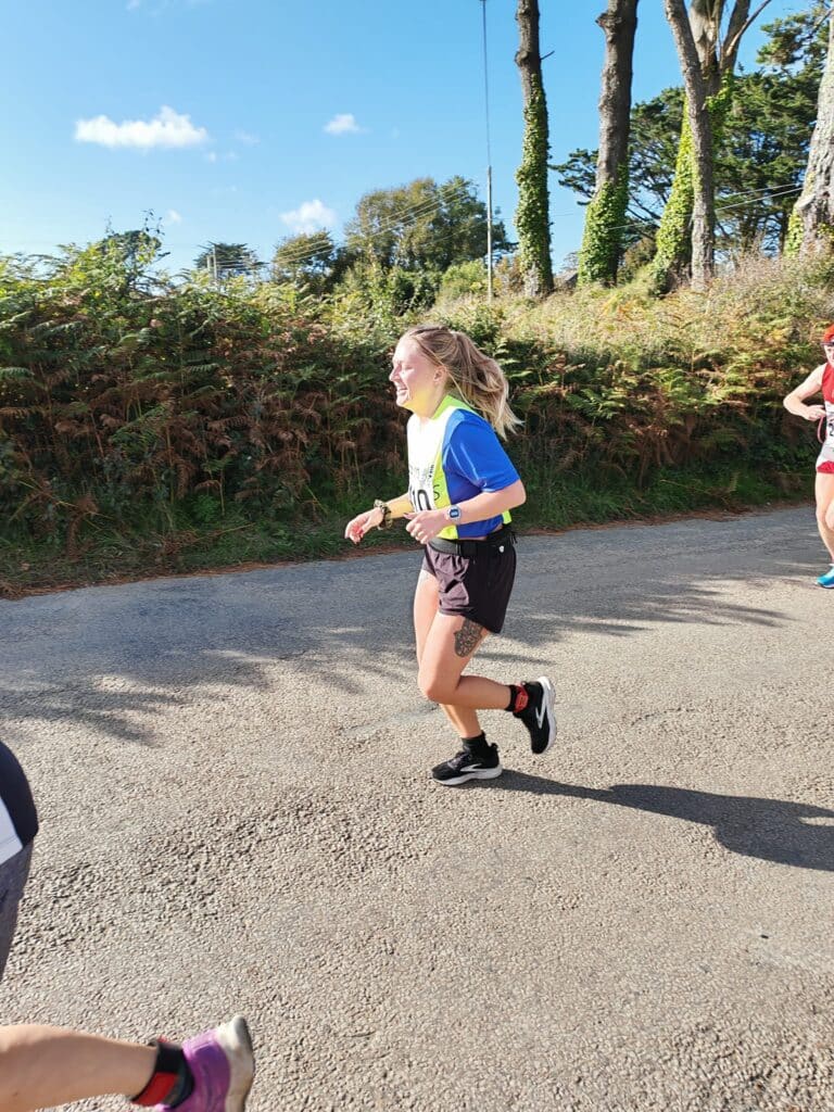 Carn Runners team at the Marazion 10K with Cornish coastline in the background