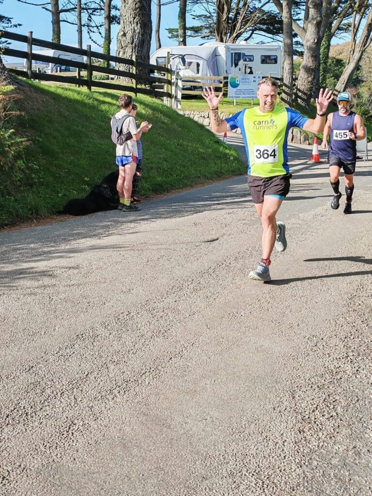 Carn Runners team at the Marazion 10K with Cornish coastline in the background