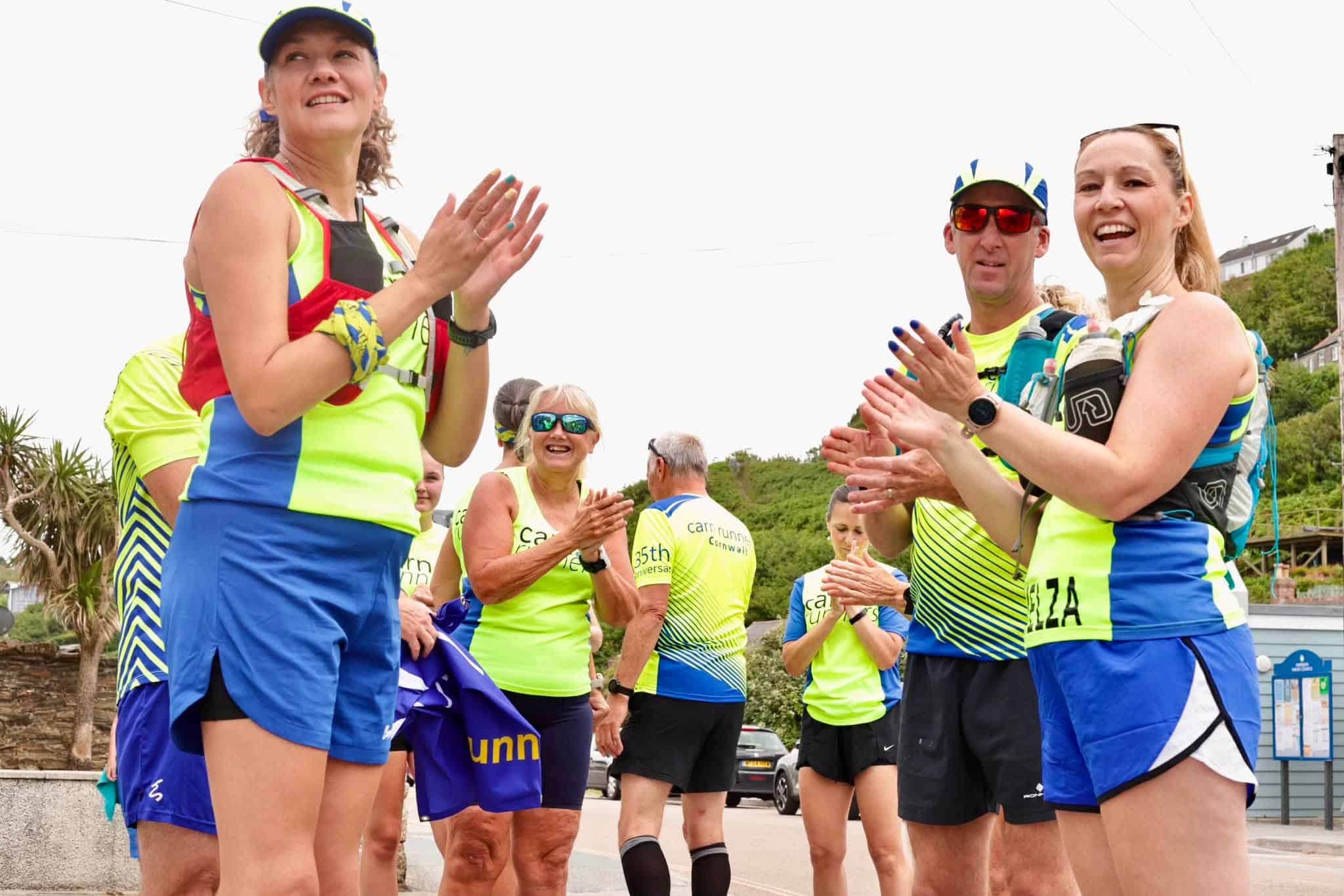 Carn Runners members celebrating at the top of Carn Brea after completing the 35-mile Coral Relay