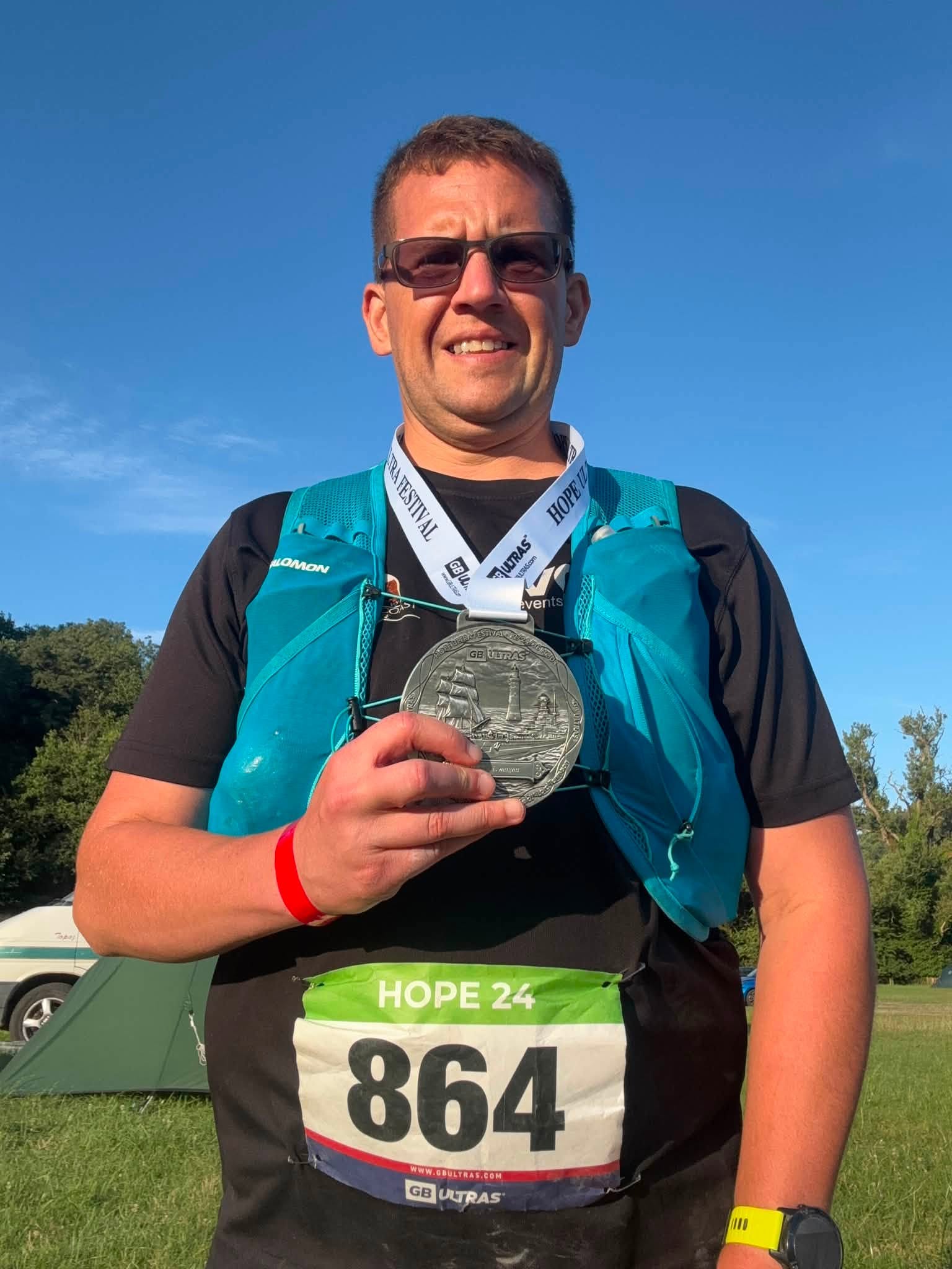 David Vaughan proudly displaying his Hope Trail Festival finisher's medal after completing 40 miles